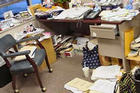 Messy office with files in piles on the desk and floor.